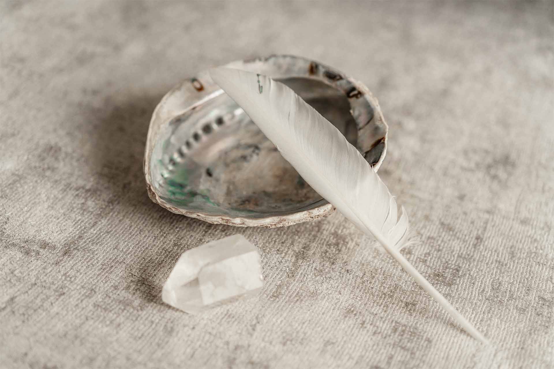 Dankbarkeit finden - Muschel mit Feder und einem liegendem Bergkristall