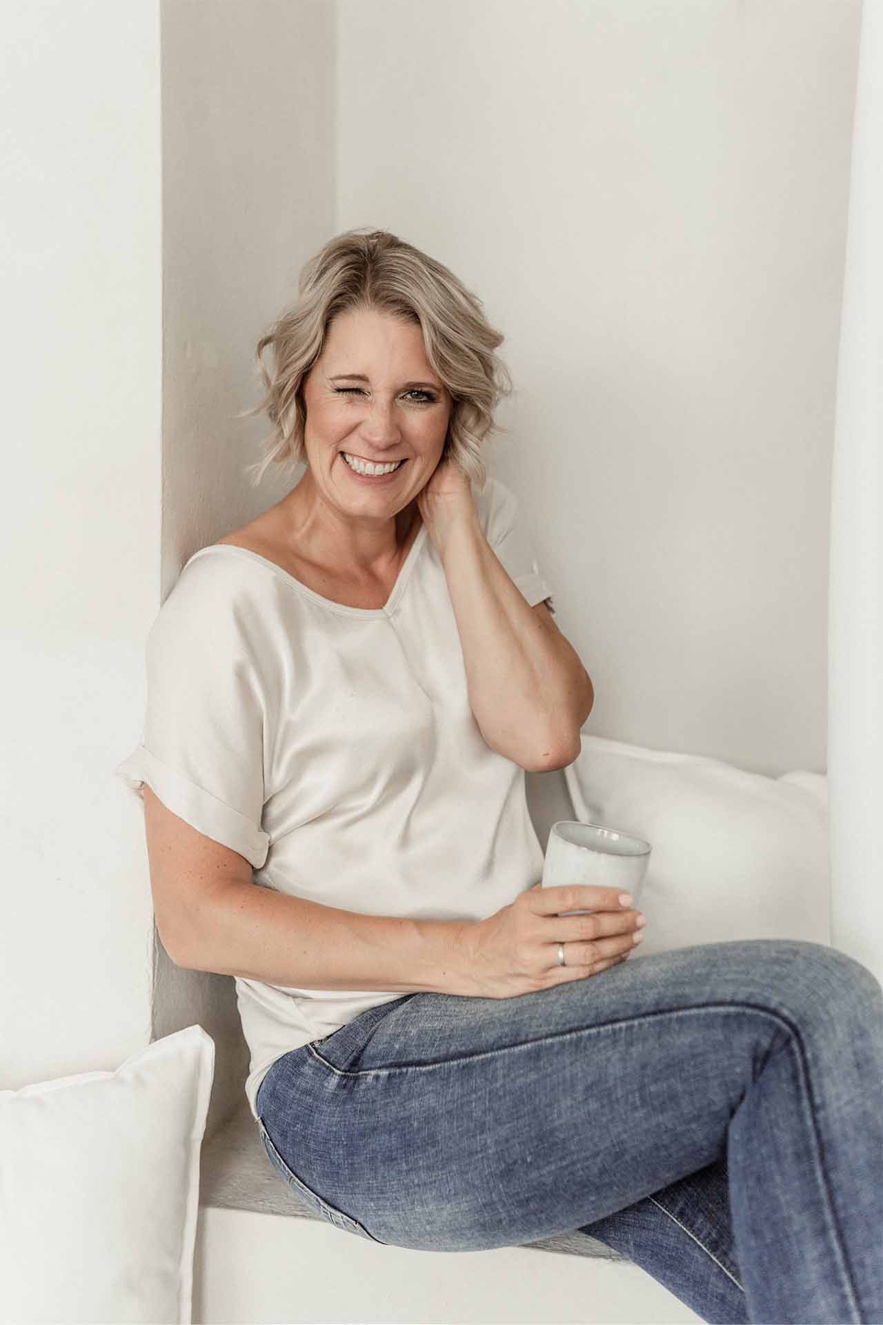 Meditation: Julia Jäger sitzt meditierend mit geschlossenen Augen im Schneidersitz auf einem Kissen